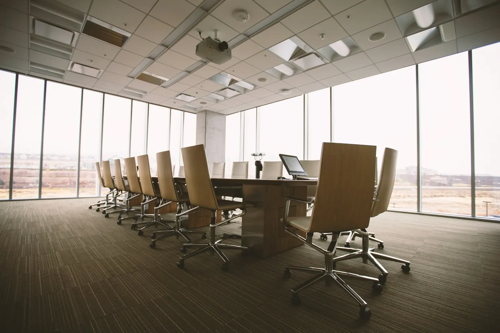 Empty boardroom with a long table and a city view through the windows