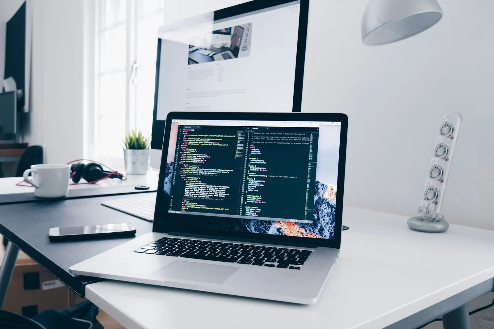 Laptop on a bright desk with code on the screen