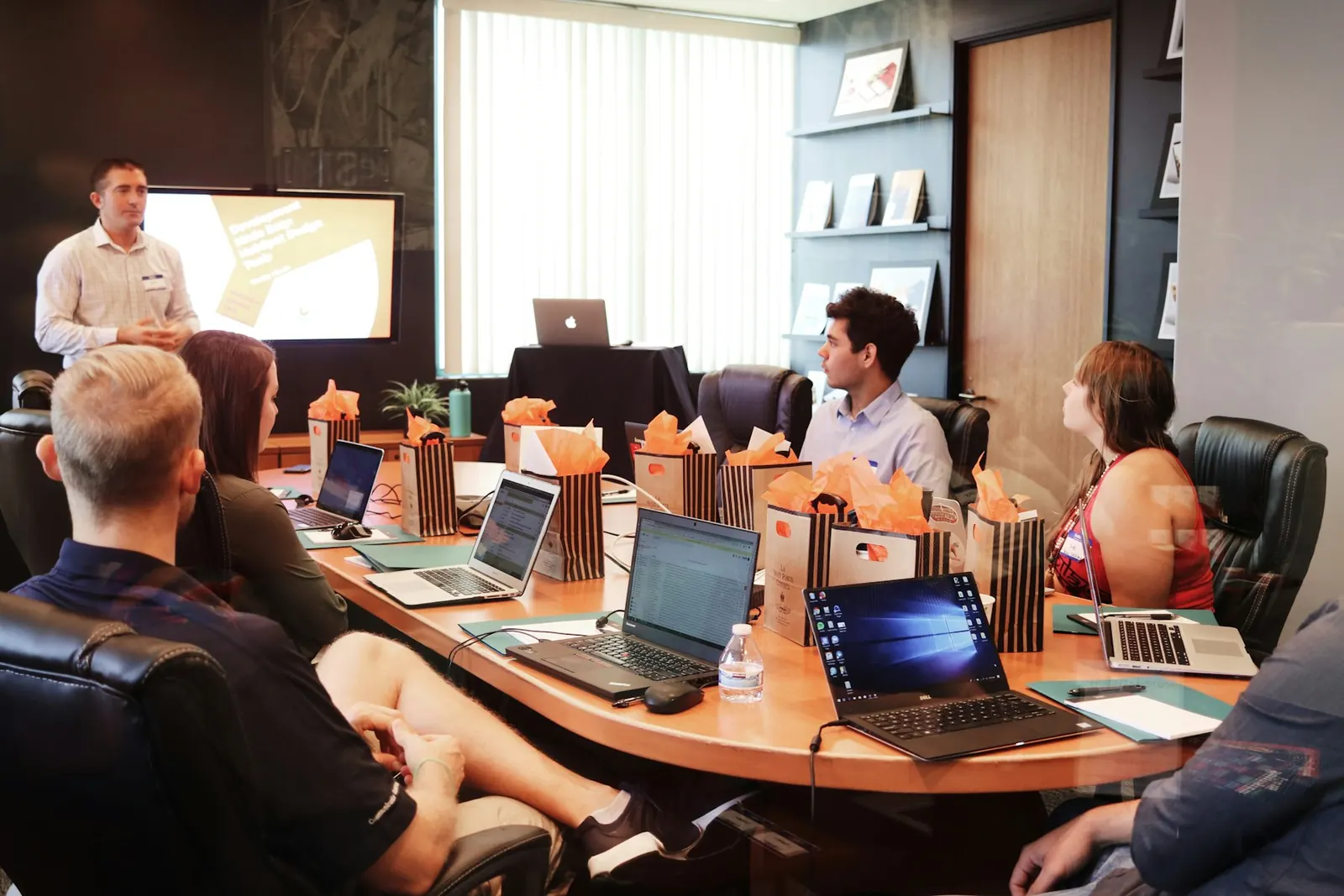 Team seated around a conference table with laptops