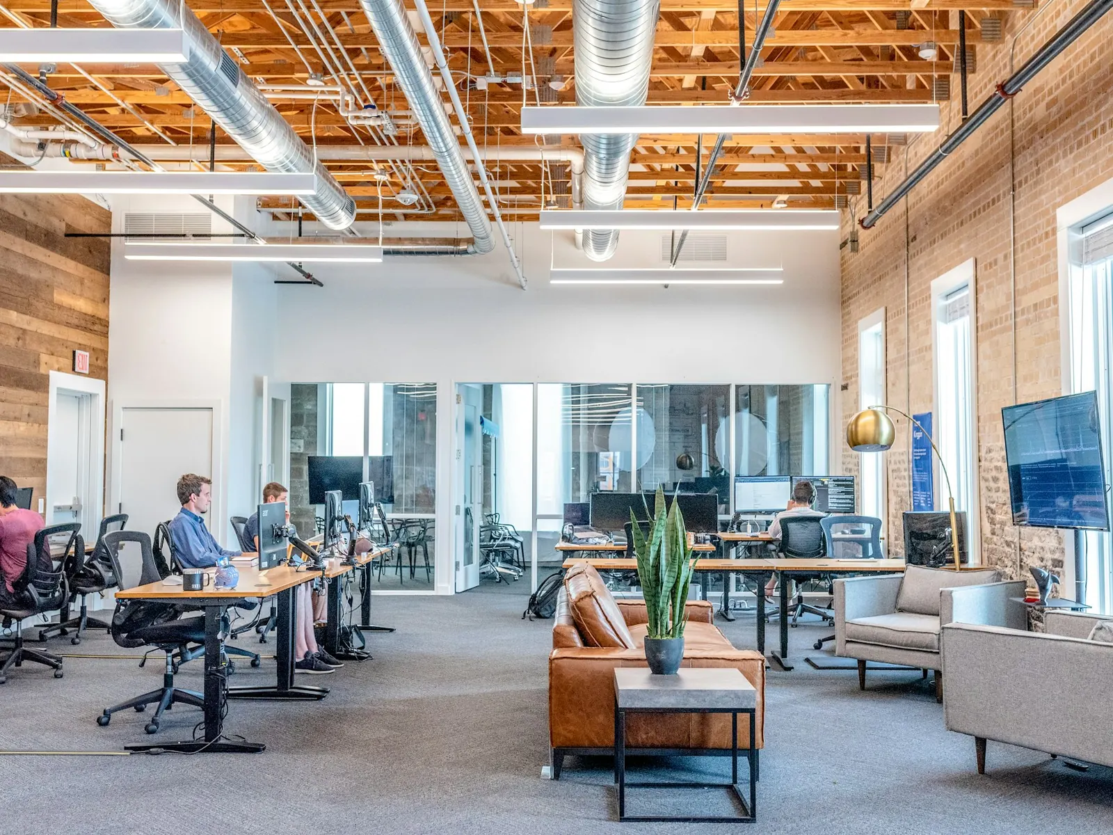 Loft-style office with people working at shared tables