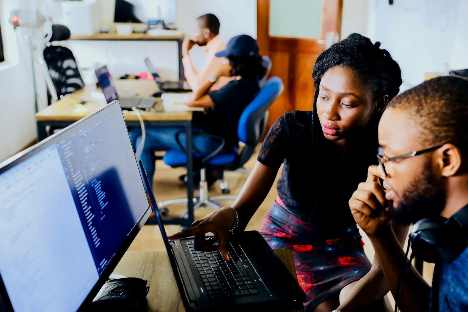 Two colleagues looking at one laptop together