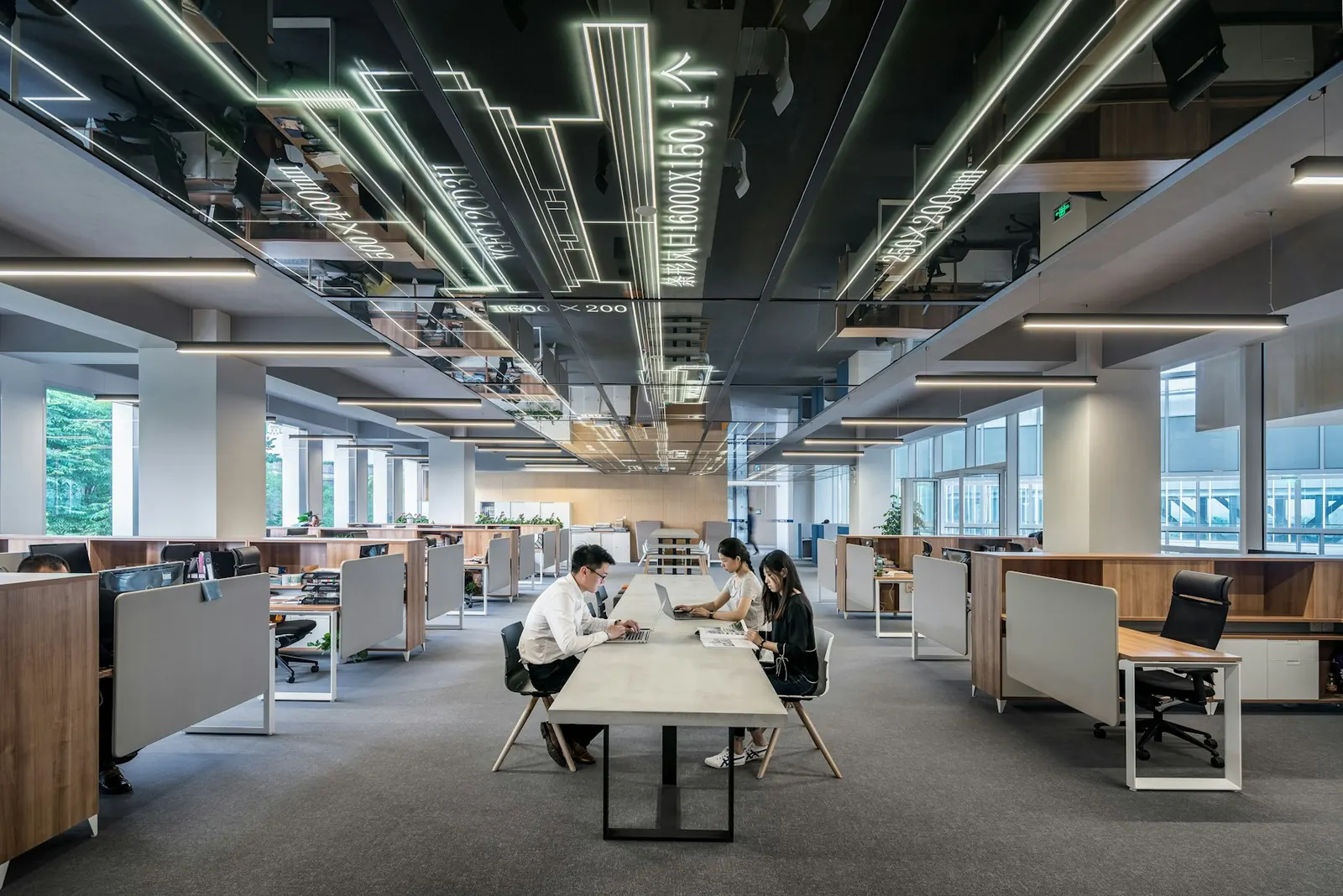 Wide open office with many desks and pendant lights